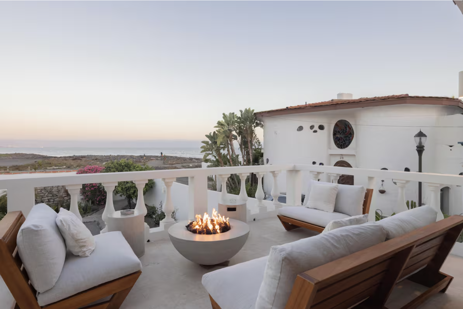Ocean-view balcony seating around a glowing fire pit
